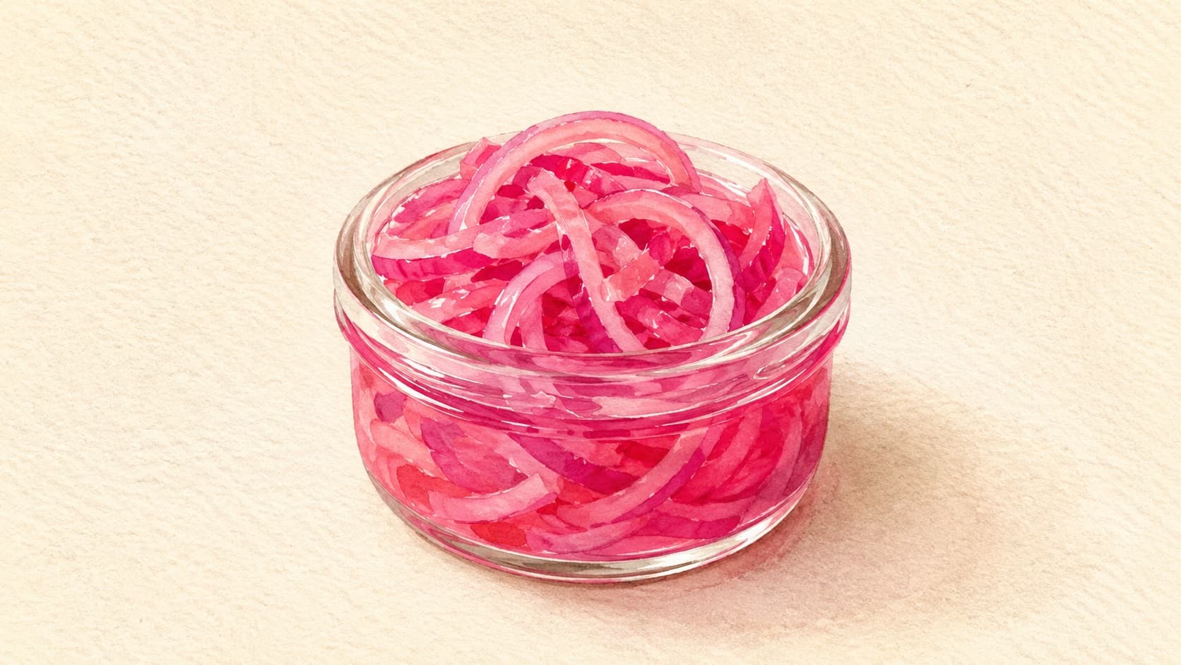 A jar of bright pink pickled red onions on a wooden table, showcasing their vibrant color.