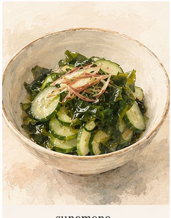 薄切りきゅうりとわかめの入った小さなガラス鉢。淡い黄金色の酢のタレがかかっている